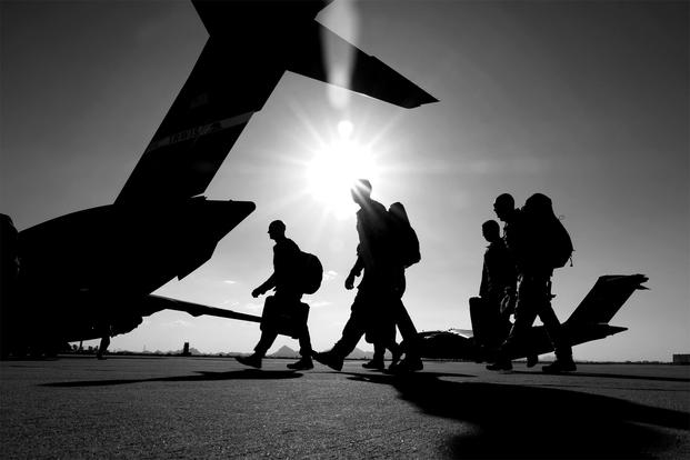 Airmen walk toward a C-17 Globemaster III aircraft on the flight line, June 1, 2019. (Andre Trinidad/Air Force)