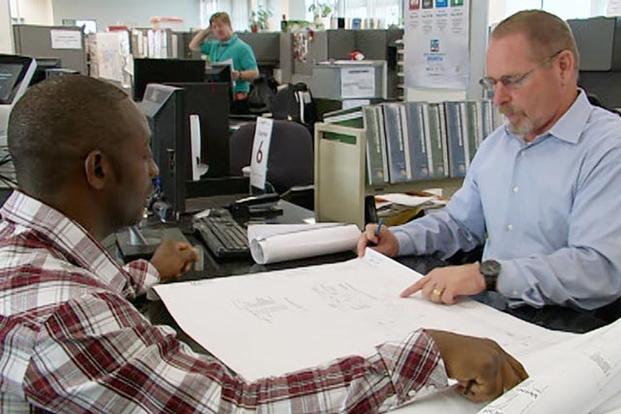 Professionals discussing at desk.